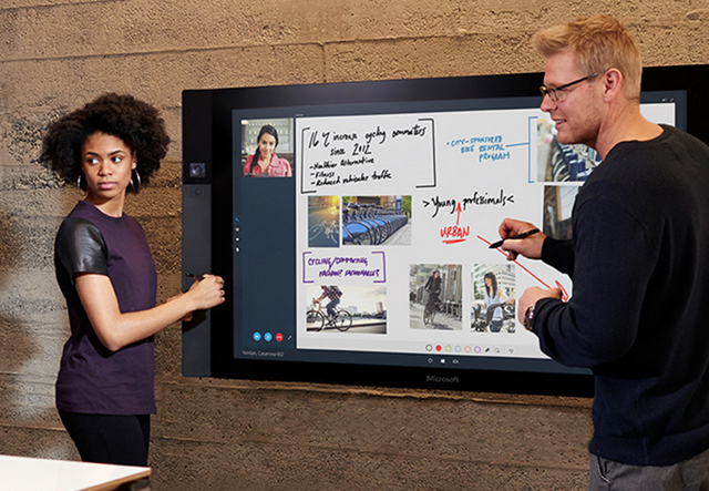 Two people working on a Microsoft Surface Hub Two people working on a Microsoft Surface Hub